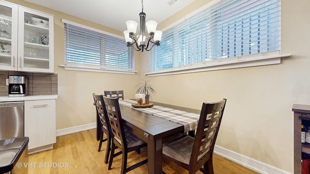 dining room featuring an inviting chandelier, baseboards, and light wood-type flooring