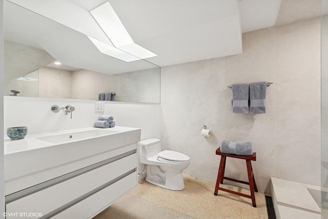 1825 W Wabansia Ave, Chicago, IL 60622 - bathroom featuring a skylight, speckle patterned floor, toilet, vanity, and tile walls