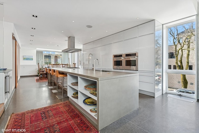 1825 W Wabansia Ave, Chicago, IL 60622 - kitchen featuring island exhaust hood, appliances with stainless steel finishes, modern cabinets, white cabinets, and a sink