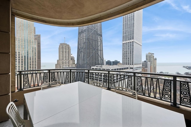 balcony featuring a water view and a city view