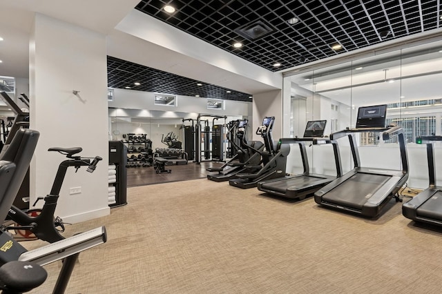 exercise room with visible vents, baseboards, and carpet