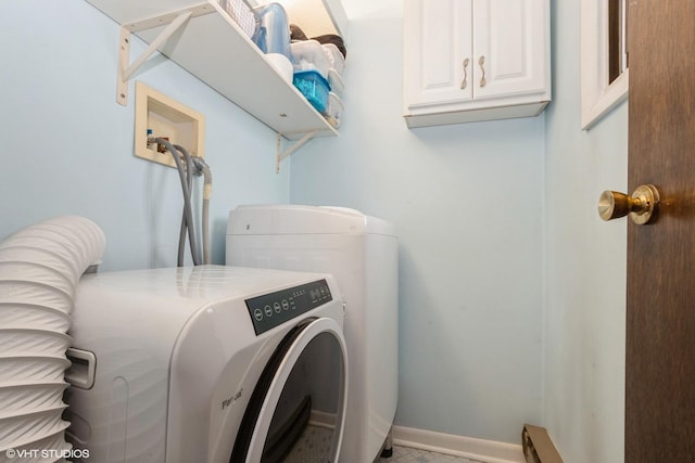 clothes washing area with baseboards, washer / clothes dryer, and cabinet space