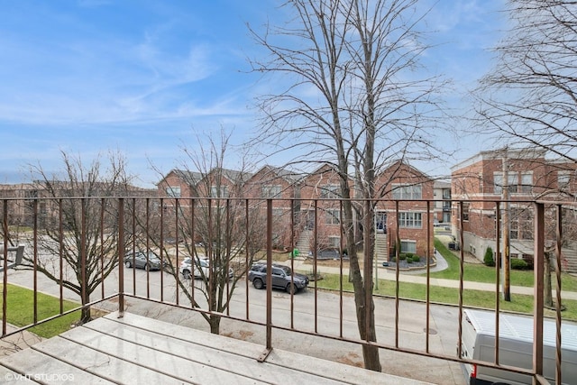 view of gate with a residential view and a lawn