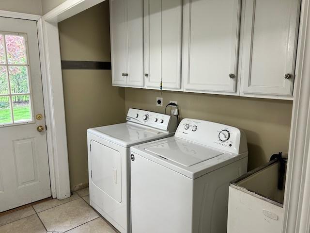 clothes washing area with light tile patterned floors, a sink, cabinet space, and washing machine and clothes dryer