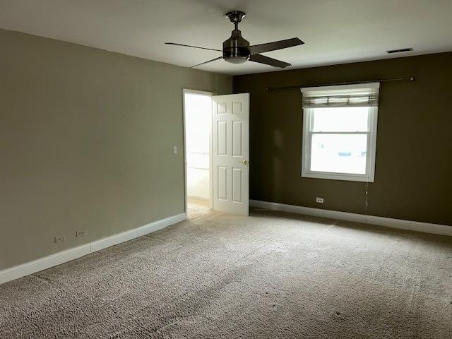 unfurnished bedroom with visible vents, a ceiling fan, baseboards, and light carpet