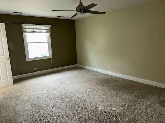 empty room featuring baseboards, light carpet, and a ceiling fan