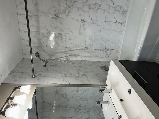 full bathroom featuring vanity and a tile shower