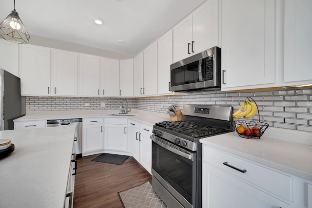 1705 Kraft Ave, Batavia, IL 60510 - kitchen with white cabinets, appliances with stainless steel finishes, dark wood-style flooring, a sink, and decorative backsplash