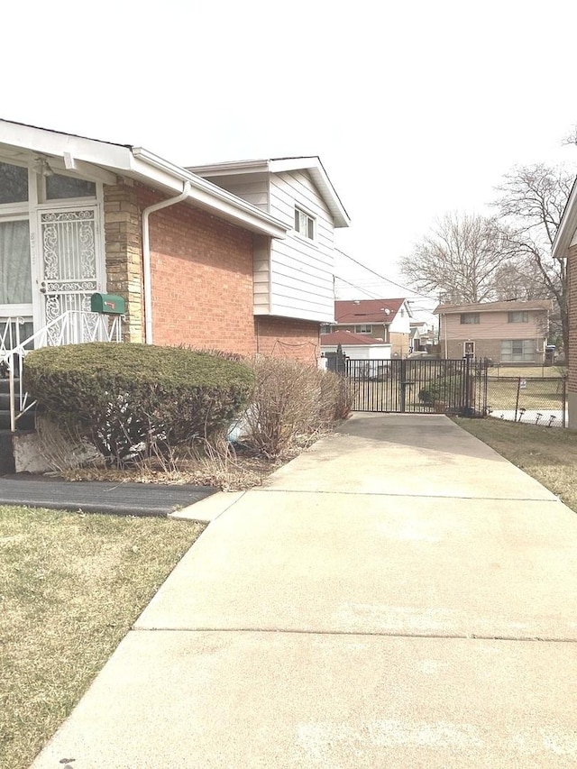 view of property exterior with driveway and brick siding