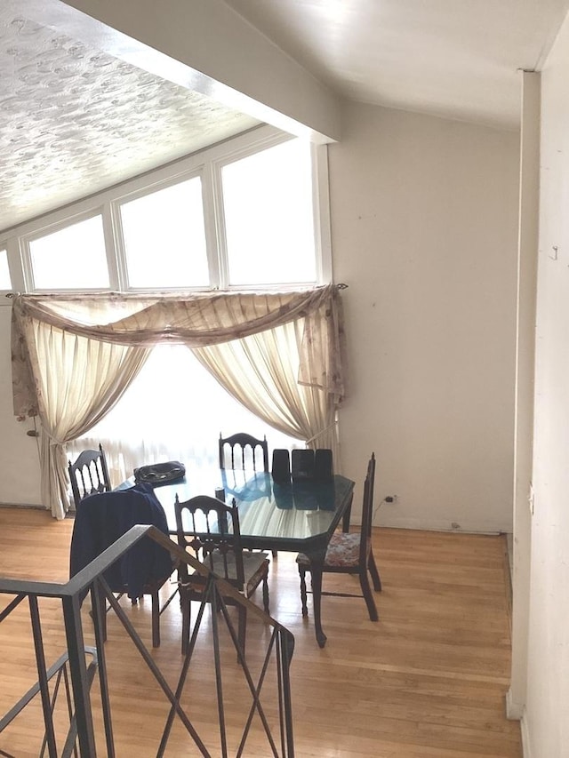 dining area with lofted ceiling, light wood-style flooring, and plenty of natural light