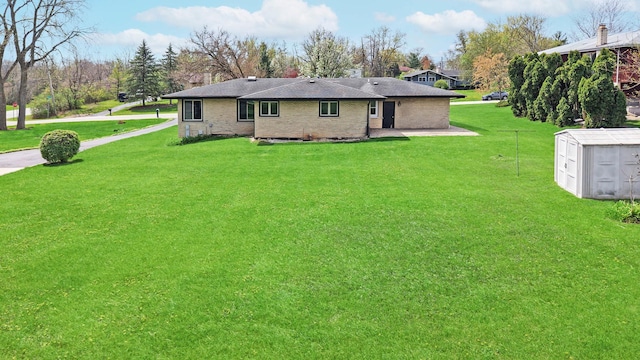 back of property with a lawn, a storage unit, and an outdoor structure