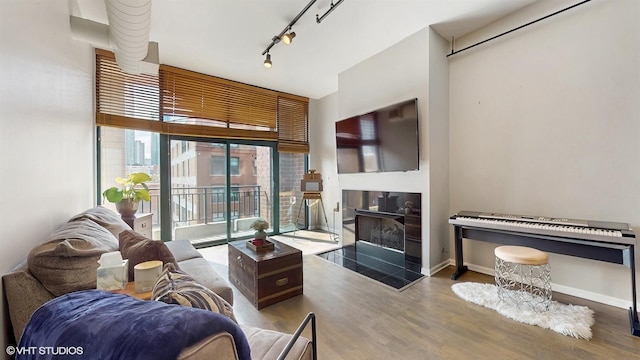 400 W Ontario St Unit 606, Chicago, IL 60654 - living area featuring a tiled fireplace, track lighting, baseboards, and wood finished floors