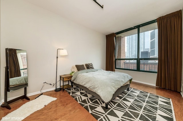 400 W Ontario St Unit 606, Chicago, IL 60654 - bedroom featuring baseboards, wood finished floors, and lofted ceiling