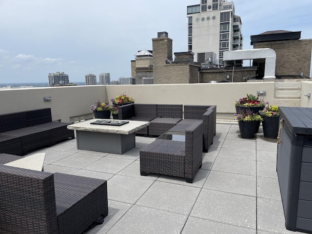 view of patio / terrace featuring a view of city and an outdoor living space with a fire pit