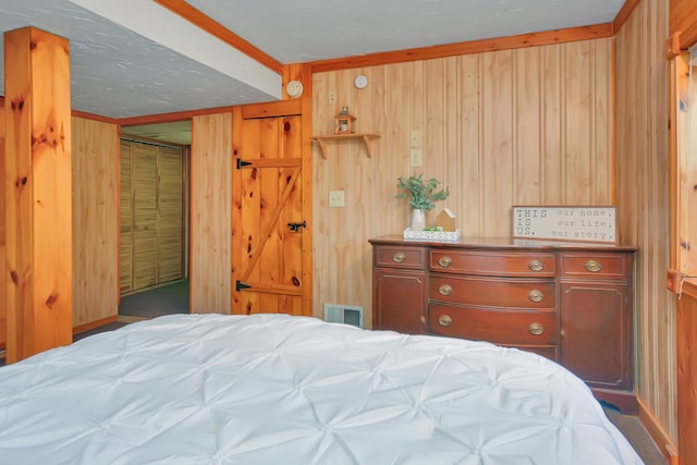 bedroom with visible vents and wood walls