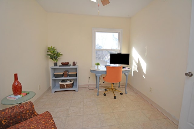 office space with a ceiling fan and baseboards
