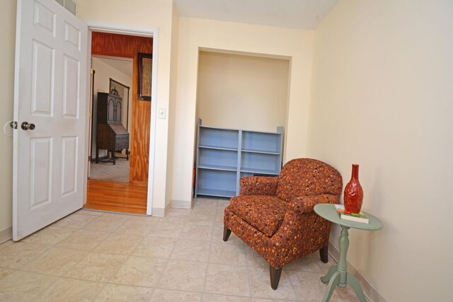 living area featuring baseboards and visible vents