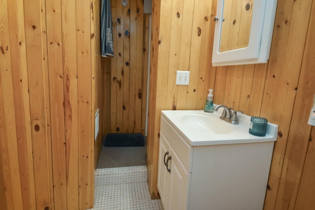 bathroom featuring vanity and wood walls