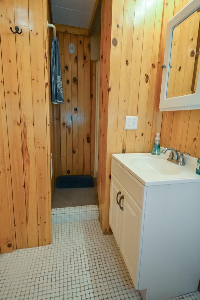 bathroom featuring vanity and wooden walls
