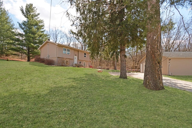 view of yard featuring driveway and a garage