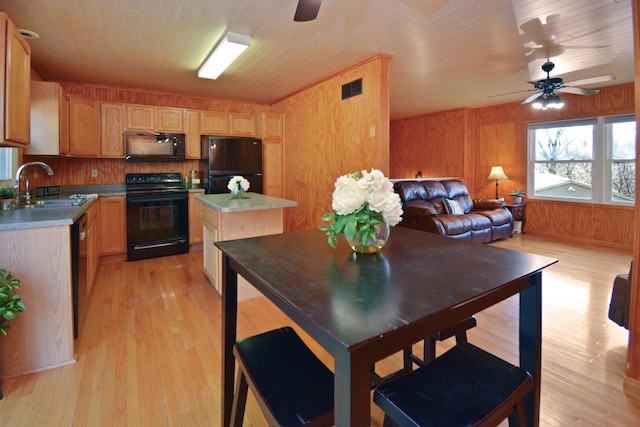 kitchen with light wood-style flooring, a sink, black appliances, and ceiling fan