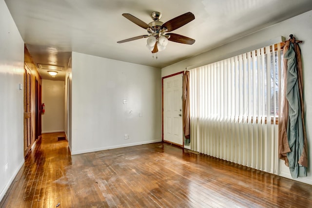 spare room with a ceiling fan, baseboards, and wood-type flooring