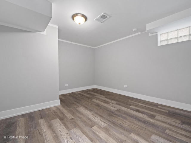 interior space featuring crown molding, wood finished floors, baseboards, and visible vents