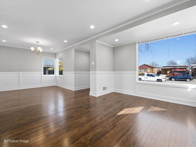 unfurnished room featuring a wainscoted wall, visible vents, wood finished floors, recessed lighting, and a chandelier