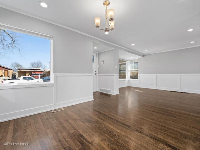 interior space featuring a notable chandelier, wainscoting, crown molding, and wood finished floors