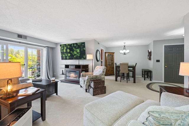 326 Park Ave Unit 38, Clarendon Hills, IL 60514 - living area featuring light carpet, a glass covered fireplace, a chandelier, and baseboards