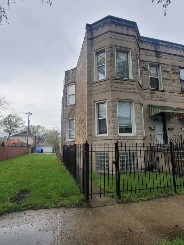6506 S Eberhart Ave, Chicago, IL 60637 - view of home's exterior featuring a yard, stone siding, and a fenced front yard