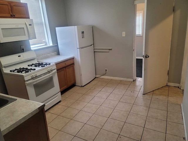6506 S Eberhart Ave, Chicago, IL 60637 - kitchen with light countertops, light tile patterned flooring, brown cabinetry, and white appliances