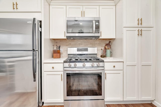 218 San Carlos Rd, Minooka, IL 60447 - kitchen with stainless steel appliances, light countertops, backsplash, white cabinetry, and light wood-style floors