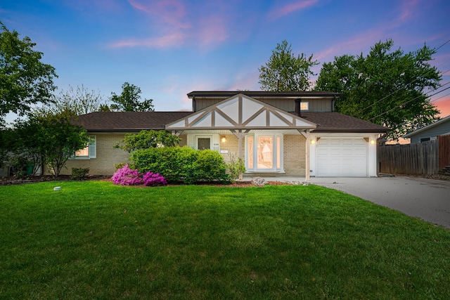 tudor home with driveway, an attached garage, and brick siding