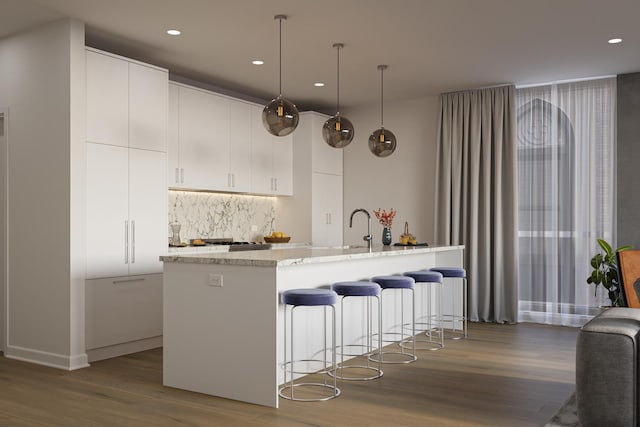 5114 S Kenwood Ave Unit 3B, Chicago, IL 60615 - kitchen with wood finished floors, a breakfast bar, recessed lighting, backsplash, and white cabinets