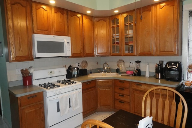 3801 W 46th St, Chicago, IL 60632 - kitchen featuring brown cabinets, a sink, white appliances, tasteful backsplash, and glass insert cabinets