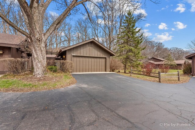 view of front facade featuring board and batten siding and aphalt driveway