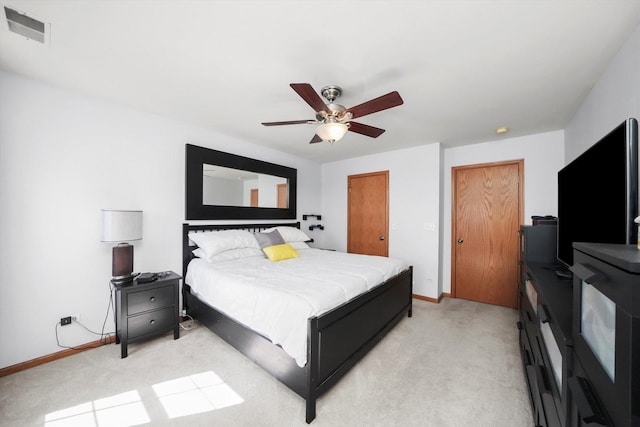 bedroom featuring visible vents, baseboards, a ceiling fan, and light colored carpet
