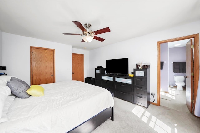 bedroom with light carpet, ensuite bath, and ceiling fan