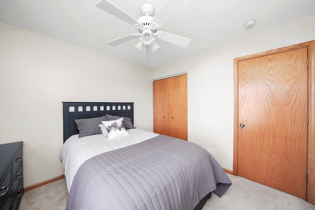 bedroom with light carpet, baseboards, multiple closets, and a ceiling fan