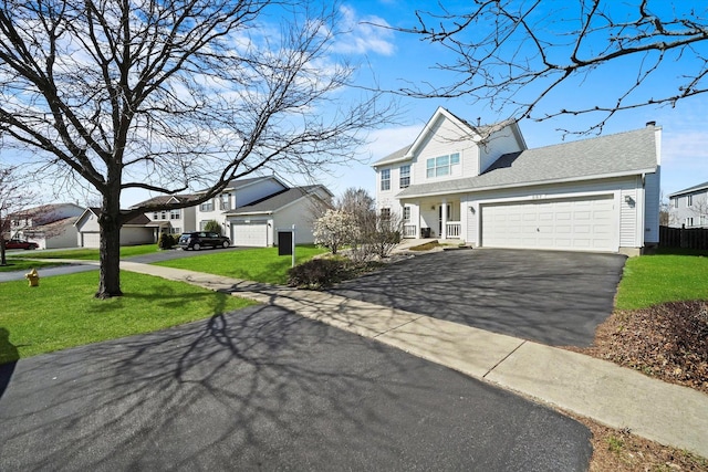 traditional home featuring a front yard, a garage, a chimney, aphalt driveway, and a residential view