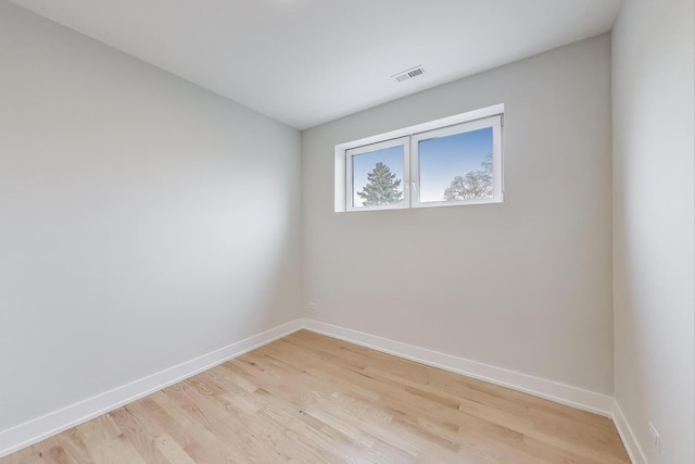 unfurnished room featuring visible vents, light wood-style flooring, and baseboards