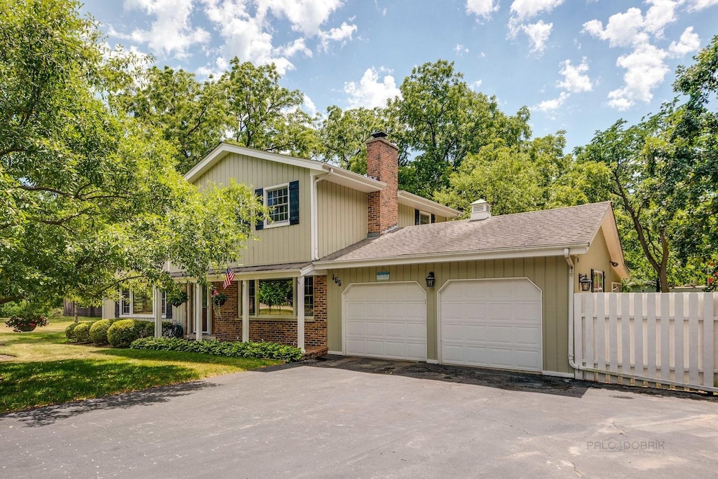 455 Hickory Haven Dr, Gurnee, IL 60031 - view of front of house featuring a chimney, an attached garage, driveway, brick siding, and a shingled roof