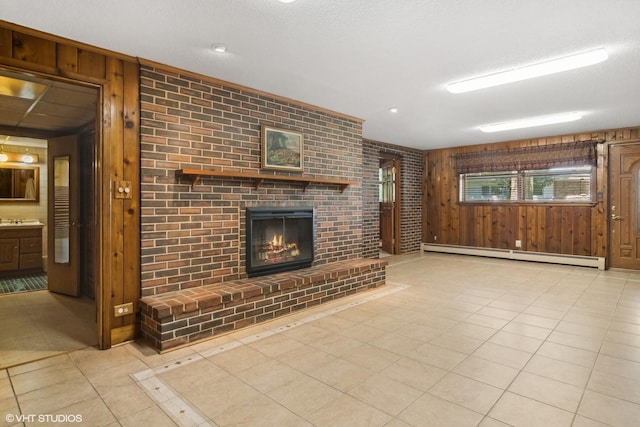 unfurnished living room featuring a textured ceiling, wooden walls, a fireplace, light tile patterned floors, and baseboard heating