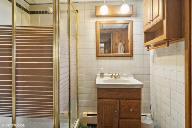 bathroom featuring a baseboard heating unit, tile walls, a shower stall, and vanity