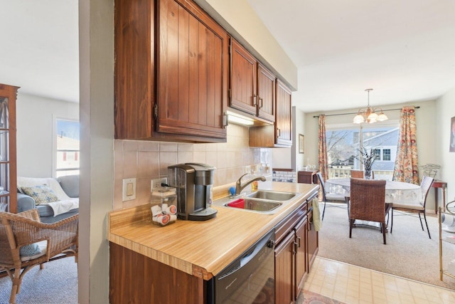 kitchen featuring plenty of natural light, a sink, decorative backsplash, dishwasher, and a chandelier