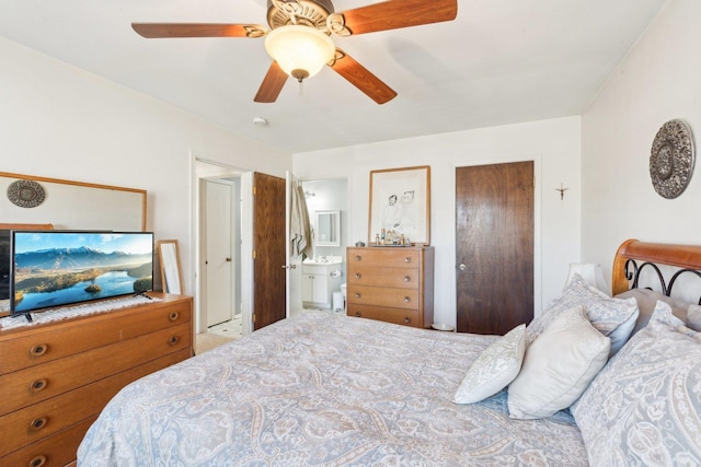 bedroom featuring carpet floors, ensuite bath, and a ceiling fan