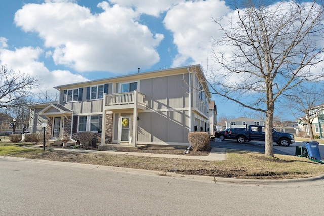 view of front of home featuring stone siding and a balcony