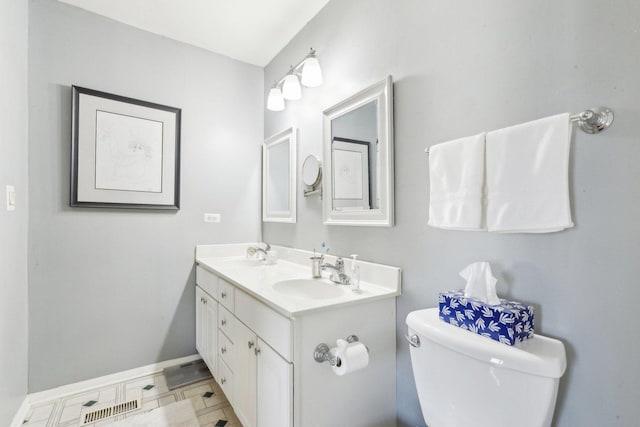 bathroom with double vanity, toilet, visible vents, and a sink