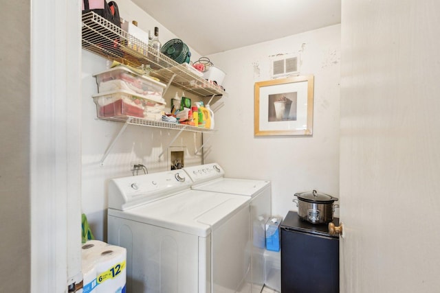 laundry area with laundry area, visible vents, and independent washer and dryer